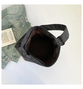 Détail intérieur d'un sac cabas à carreaux avec doublure marron et fermeture éclair