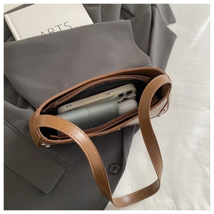 Interior view of brown leather crescent bag showing storage space for phone and essentials