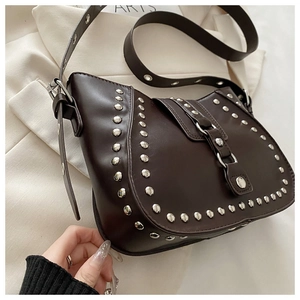 Détail du sac besace marron vintage avec clous argentés et bandoulière réglable en cuir