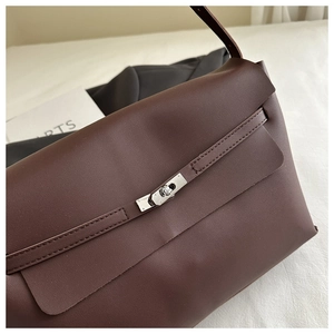 Close-up of dark brown tote bag with silver metal swivel lock and fine stitching
