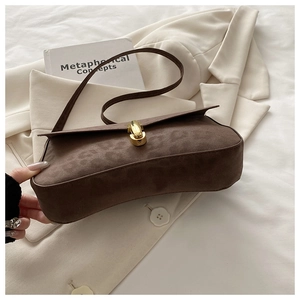 Detail of leopard print embossed suede shoulder bag with elegant gold metal twist lock