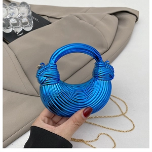 Detail of blue metallic pleated crescent bag with gold chain and ball handle decoration