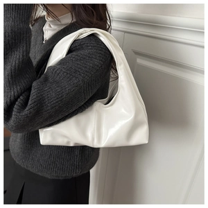 Detailed view of the white glossy leather shoulder bag with sleek minimalist texture