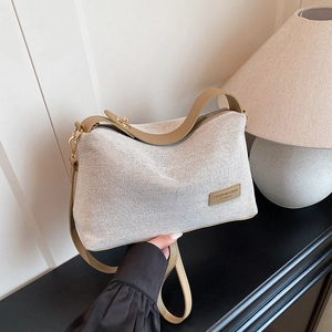 Chic beige woven shoulder bag with brown leather trim and stylish golden hardware