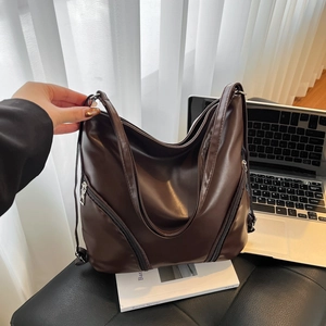 Sac fourre-tout minimaliste marron foncé avec fermeture éclair argentée sur siège en cuir