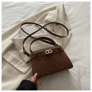 Detailed view of leopard print suede handbag with gold clasp on a minimalist background