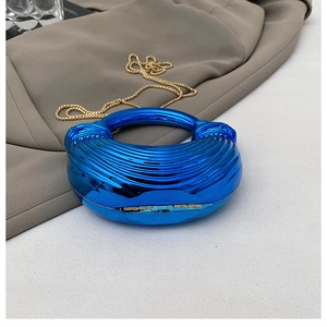 Detail of blue electroplated acrylic clutch bag with metallic folds and gold chain strap