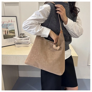 Detail of vintage camel tote bag with matte leather texture and long shoulder strap