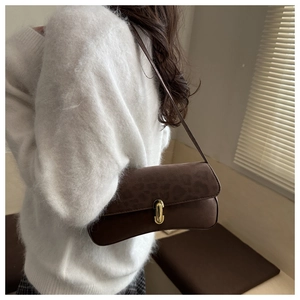 Detail view of the retro leopard print suede flap and golden buckle on the shoulder bag