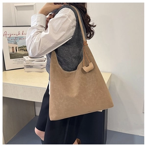 Detail of khaki frosted leather tote bag with vintage texture shown on a model