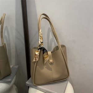 Beige faux leather large tote bag with decorative scarf on handle for daily commuting