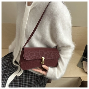 Detail of burgundy leopard print shoulder bag with elegant golden magnetic metal clasp