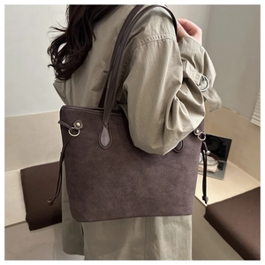 Dettaglio della borsa tote grande in pelle scamosciata marrone scuro con fibbie in metallo