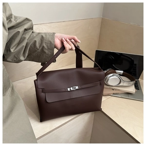 Detail of dark coffee leather tote bag with silver twist lock and envelope flap closure