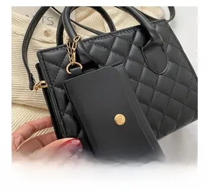 Close-up of black quilted leather mini bag charm with golden metal chain detail