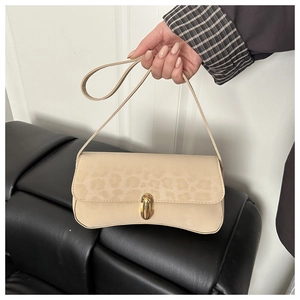 Detail of leopard print flap and gold twist lock on beige underarm shoulder bag