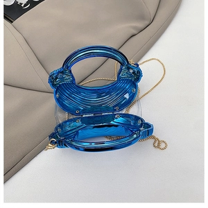 Detailed interior view of a bright blue shell-patterned acrylic clutch with gold chain
