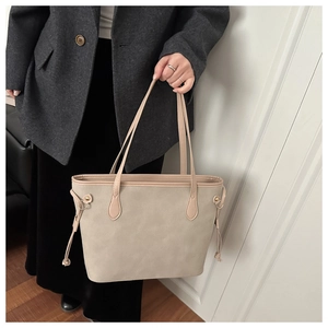 Dettaglio della borsa tote in pelle opaca beige con coulisse laterali e sottili spalline