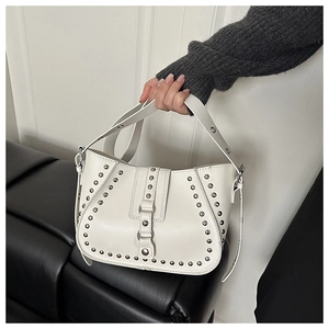 Détail du sac besace en cuir blanc avec rivets argentés et bandoulière ajustable