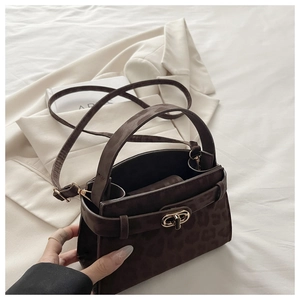 Detail of leopard print suede handbag with elegant golden twist lock and top handle