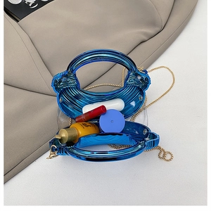 Top view of blue acrylic shell clutch showing internal space with gold chain strap