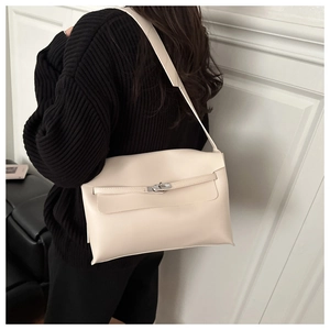 Detail of a chic cream leather handbag with silver twist lock and crossbody strap