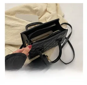 Internal view of black quilted crossbody bag with double zippers and small card pouch