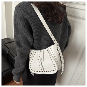 Détail du sac de selle blanc en forme de lune avec clous argentés et large bandoulière