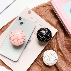 Detailansicht der Handyhalterungen in Pink, Schwarz und Weiß mit goldenen Linienmustern