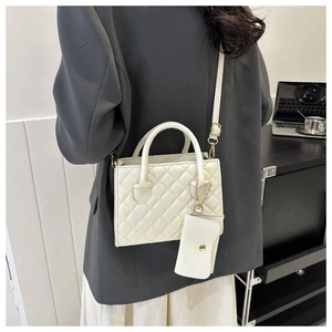 Detailed close-up of white quilted crossbody bag with matching chain coin purse accessory