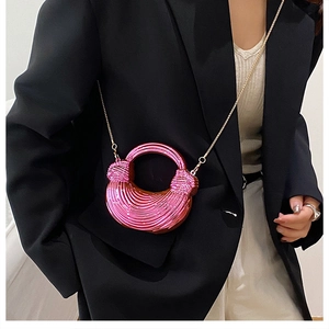 Macro detail of mini metallic pink round clutch with chic textured spiral design