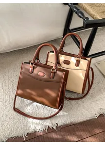Vista dall'alto di borse tote vintage in ecopelle marrone e beige su un tappeto