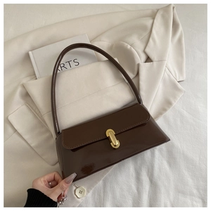 Détail du sac à main en cuir verni marron avec fermoir métallique doré sophistiqué
