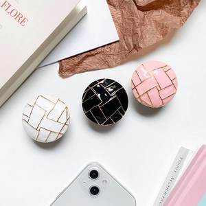 Makroaufnahme von Handy-Halterungen mit geometrischem Marmormuster in Weiß, Schwarz und Rosa