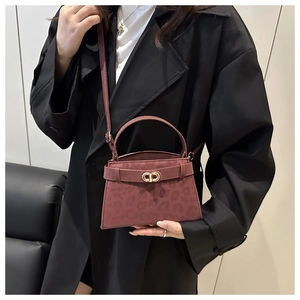Detail of dark red leopard print kelly bag with golden round buckle worn by a model