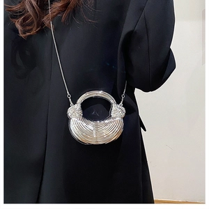 Close-up of silver striped acrylic handbag with hollow round handle and chain strap