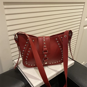 Sacoche selle rouge rétro avec rivets argentés et boucle métallique sur fond blanc