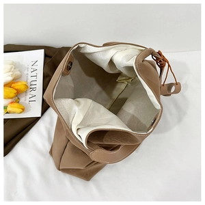 Top view of large brown tote bag interior with textured leather and metal snap closure