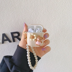Detail showing silicone AirPods Pro case with 3D bear, daisy and pearl lanyard strap