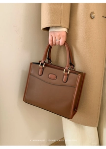 Dettaglio della borsa tote retrò minimalista marrone scuro con eleganti finiture oro