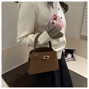 Brown leopard print handbag with golden metal buckle carried by a model in casual attire