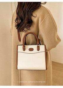 Vue mannequin d'un grand cabas rétro minimaliste en beige et marron avec bandoulière