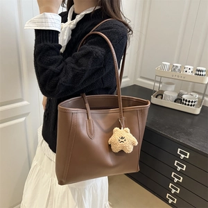Retro brown leather tote bag with star charm worn by a model for a chic commute