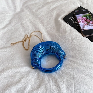 Blue acrylic evening bag with metallic finish, circular handle, and gold chain strap