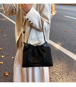 Close-up of leopard print tote bag with silver chain strap and Creative Girl logo