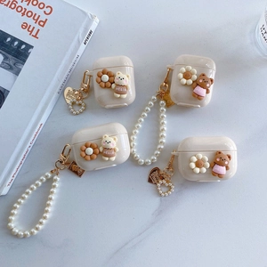 Detail of cream silicone AirPods case featuring 3D bears, flowers, and pearl chains
