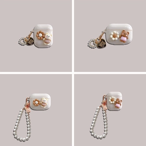 Detail view of silicone AirPods case with 3D bear, floral charms and pearl wrist strap