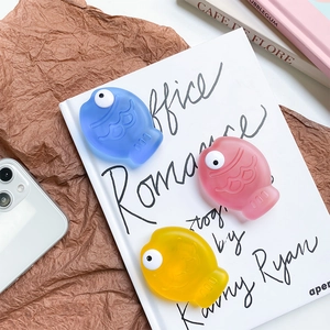 Close-up of cute 3D fish phone socket stands in blue, pink, and yellow colors