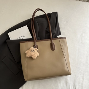 Retro khaki tote bag with brown handles and star plush pendant on white fabric background