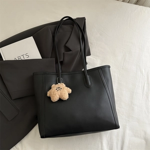Minimalist black tote bag with star plush charm and shoulder straps for daily commute